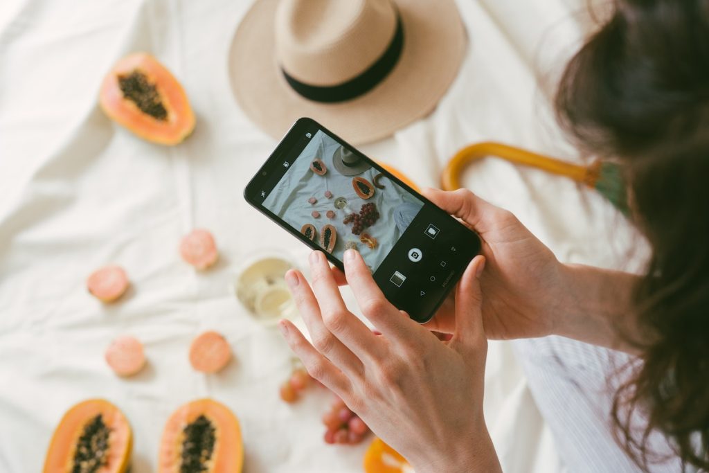 A woman capturing fruit on a bed with a personalized touch.