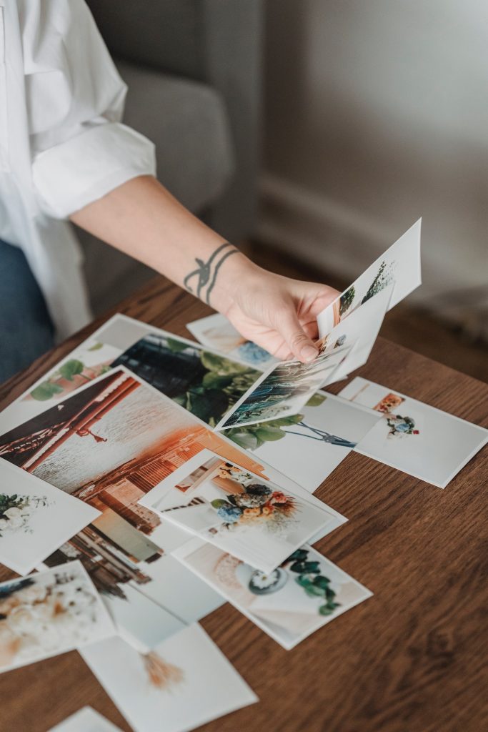 A woman displaying printed Christmas cards at a table.