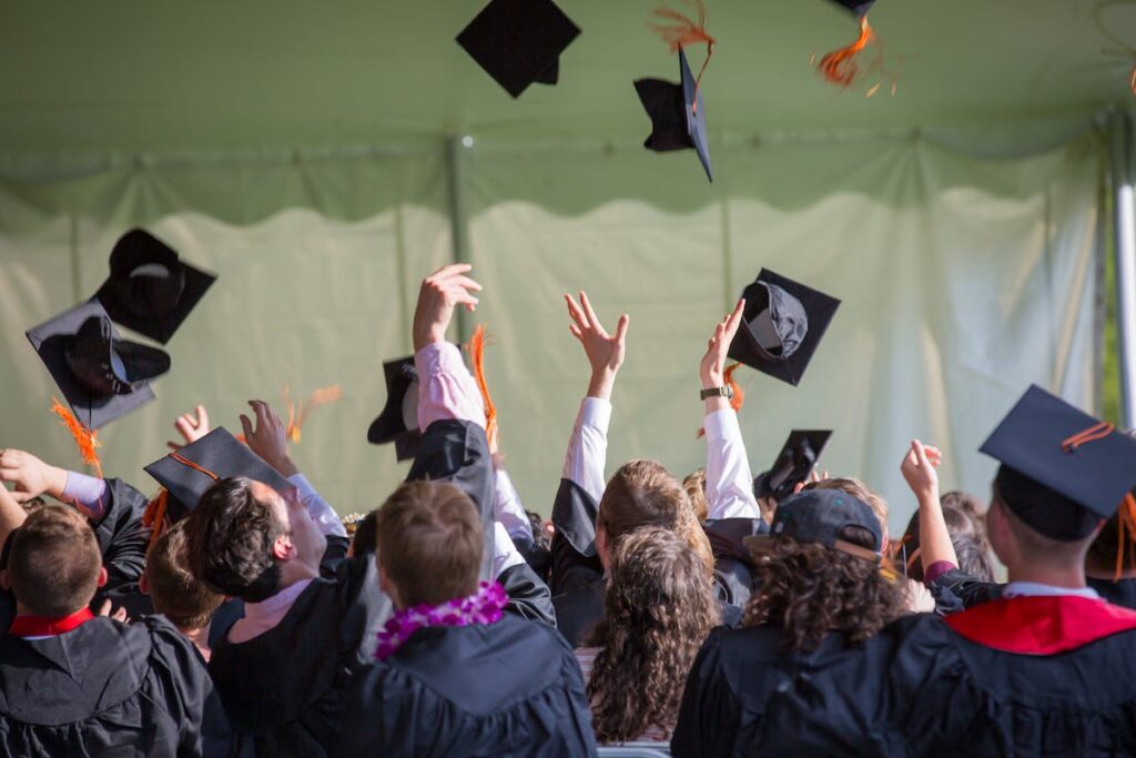 A group of graduates tossing their caps in the air, captured in a memorable photograph by Personal Touch Printing.