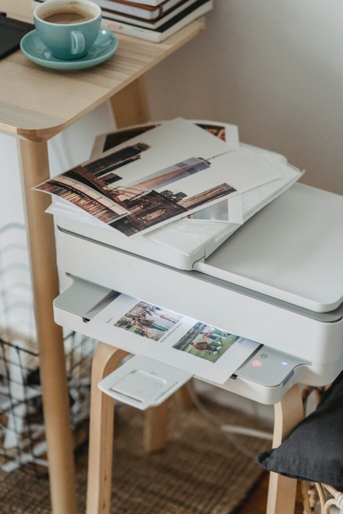 A printer sitting on a table next to a cup of coffee, ready to print party photos with printing on site.