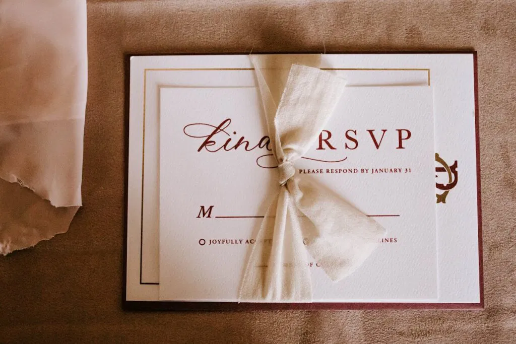 Elegant wedding RSVP card with a cream ribbon on a textured background, featuring personal touch printing.
